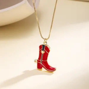 Gros plan détail d'un collier pendentif botte de cowboy émaillée rouge élégant et chic.