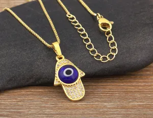 Gold plated Hamsa hand evil eye necklace pendant detailed close up crystal zircon jewelry