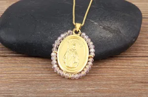 Collier pendentif ovale plaqué or avec portrait religieux et perles en acrylique rose.
