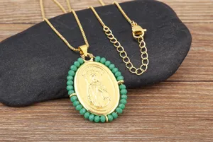 Collier pendentif saint ovale plaqué or avec bordure de perles vertes, détail de chaîne.