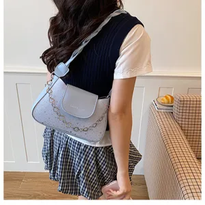 Stylish light blue underarm shoulder bag with elegant metal flower chain and chic flap detail.