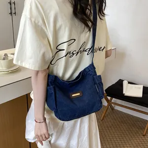 Detail view of casual denim crossbody shoulder bag with large capacity and side pockets for daily use.