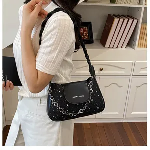 Stylish women's black underarm shoulder bag with star glitter, braided strap and chain.