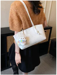 Minimalist solid color shoulder tote bag for women, commute handbag with cute plush charm.