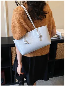 Detailed view of the light blue stylish shoulder tote bag with elegant knot handles.
