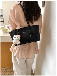 Detailed view of women's black PU leather tote shoulder bag with cute plush bear pendant.