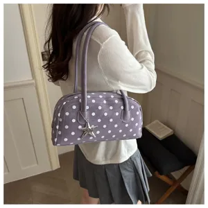 Detail shot of a purple polka dot shoulder bag with a star charm for women daily commuting.