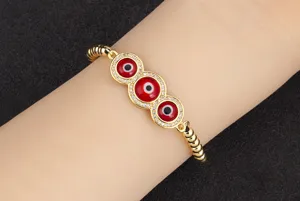 Vue rapprochée du bracelet de perles œil turc plaqué or avec des zircons rouges brillants.