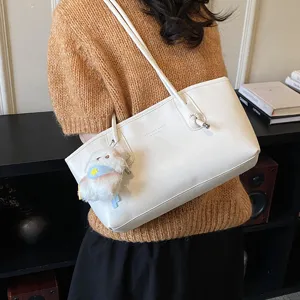 Minimalist solid white shoulder tote bag for women, stylish casual commuting handbag with plush charm.