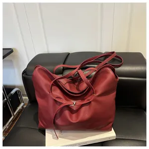Stylish burgundy leather tote bag for women, slouchy shoulder bag with chic belt closure.