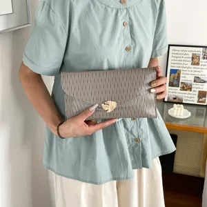 Detailed view of stylish wrinkled envelope clutch bag with unique gold clasp for chic daily commute.
