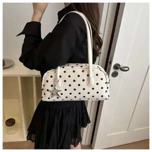 Trendy black and white polka dot shoulder pillow bag for women, chic commuting handbag.