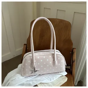 Pink polka dot shoulder bag for women, stylish niche design handbag with star charm accessory.