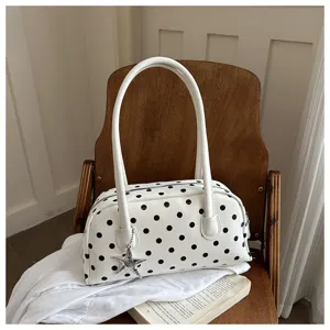 Detailed view of the white polka dot shoulder bag, highlighting star charm and texture.