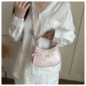 Details of the pink polka dot hobo shoulder bag with cute bow and heart pendant for daily wear.