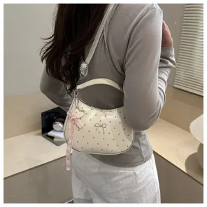 Cream polka dot hobo shoulder bag with bow and ribbon pendant, stylish casual commuter purse.