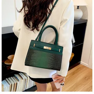 Detailed view of the stylish green handbag featuring a crocodile pattern and metal lock.