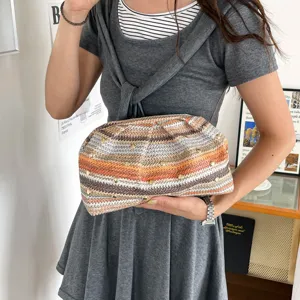 Sac pochette tressé élégant pour femme avec rayures multicolores et clous métalliques.