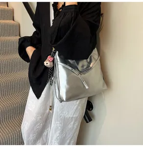 Silver metallic shoulder tote bag for women, large capacity commuter crossbody bag with cute charm.