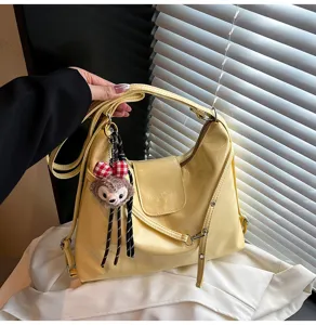 Yellow PU leather shoulder tote bag detail view showcasing the stylish plush charm and strap.