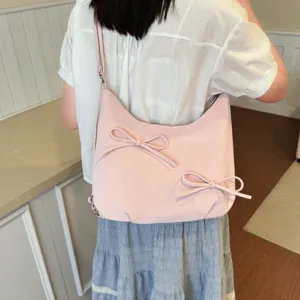 Detailed view of the pink slouchy hobo shoulder bag featuring cute bow decorations.