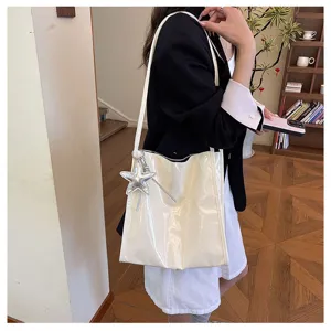 White patent leather shoulder tote bag with silver star pendant, casual commuting daily accessory.