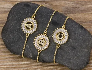 Gold plated initial letter bracelet with sparkling cubic zirconia round pendant charms for women.