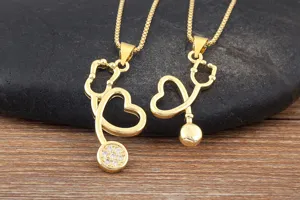 Gold plated stethoscope heart pendant necklace detail, fashion medical jewelry accessory.