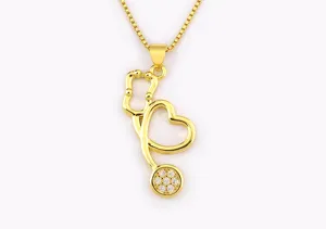 Gold stethoscope pendant necklace detail showing heart design and sparkling stone set chest piece.