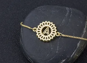 Close-up detail shot of a gold-plated alphabet charm bracelet with sparkling micro-set zircons.