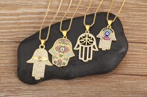 Gold plated Hamsa hand necklace set with sparkling cubic zirconia evil eye pendants.