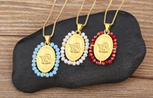 Collana con ciondolo ovale ala d'angelo placcato oro e perline di cristallo colorate.