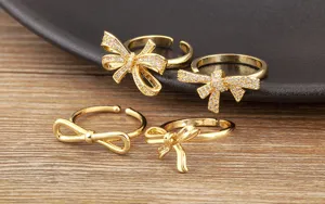 Nahaufnahme von vier goldenen Schleifenringen mit Zirkonia und glattem Metallfinish.