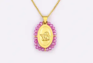 Primo piano dettaglio della collana con ciondolo ad ali d'angelo dorate con perle rosa.