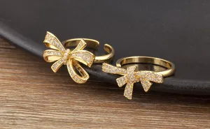 Detailansicht vergoldeter Schleifenring mit funkelnden Zirkoniasteinen, elegantes offenes Design.
