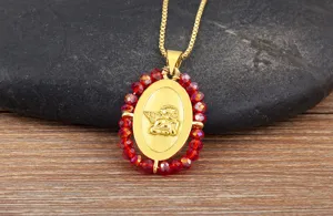Collana con ciondolo angelo placcato oro con bordo di perle di cristallo rosso e delicata catena.