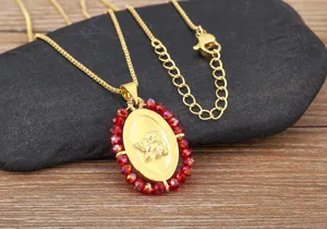Collana con ciondolo ad ali d'angelo placcata in oro e perline di cristallo, primo piano.
