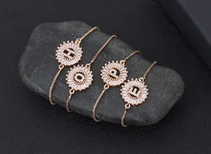 Close-up detail of four rose gold letter charm bracelets with sparkling cubic zirconia.