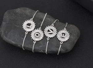 Close-up detail of silver adjustable initial letter bracelets with sparkling cubic zirconia.