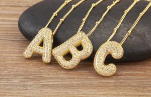 Collana con ciondolo a lettera dell'alfabeto in zirconi micropavé dorati con catena.