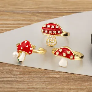 Detailed close-up view of three cute red enamel mushroom open rings with sparkly stones.