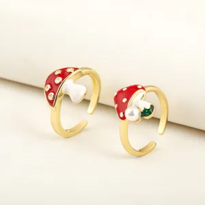 Close-up details of the cute mushroom ring showcasing red enamel and gold plated band texture.