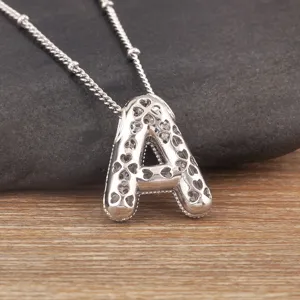 Silver-plated copper balloon letter A pendant necklace with hollow heart details and chain.