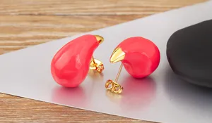 Detailed close-up of pink enamel teardrop stud earrings with 18k gold plated tips and backs.