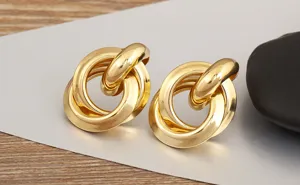 Vista dettagliata di eleganti orecchini a cerchio dorati intrecciati, design geometrico.