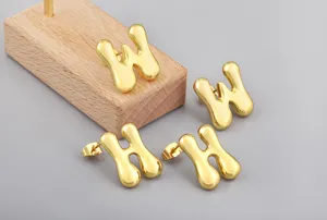 Gold puffy letter earring detail view, showcasing smooth surface and unique 3D design.