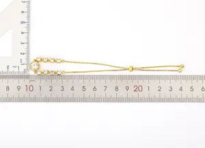 Vista detallada del brazalete ajustable de circonita cúbica con regla de medición.