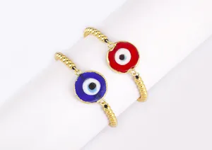 Gros plan sur les bracelets mauvais œil avec des perles dorées et des pendentifs colorés.