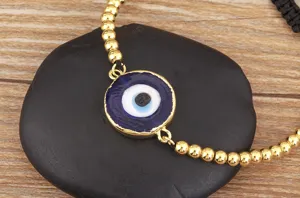 Gros plan détail du magnifique bracelet mauvais œil turc avec des perles dorées.