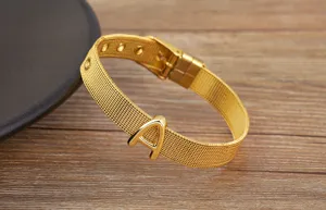 Gold plated mesh letter bracelet detail, adjustable watch strap style with initial charm.